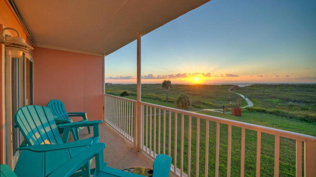 two chairs on a balcony with a view of the sunset at Beachfront Condo Prvt Balcony w View Pool Access Beach Happy by AvantStay in Port Aransas