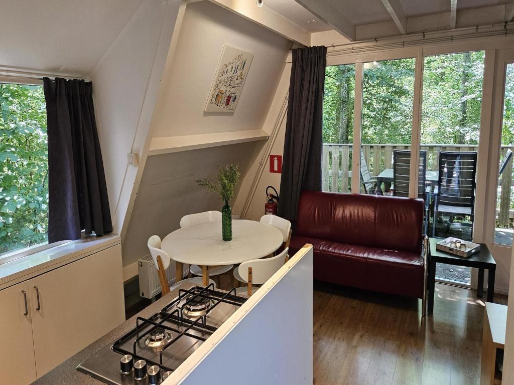 uma cozinha e sala de estar com uma mesa e um sofá em Peaceful Ardennes Getaway for 4 Guests em Septon