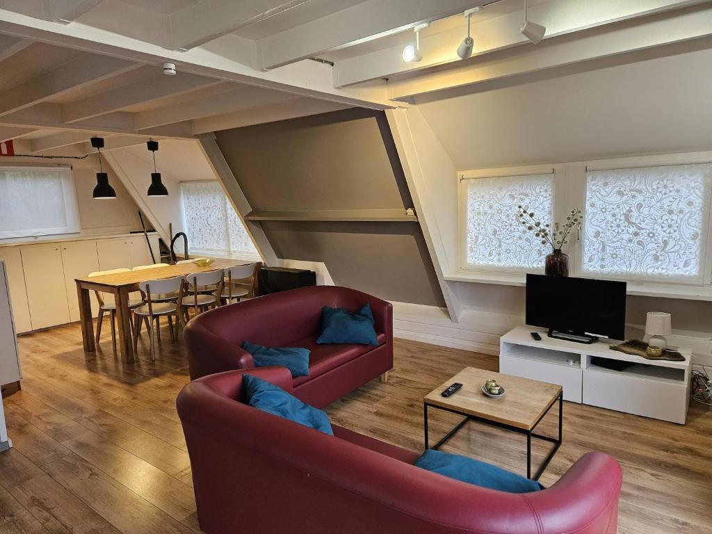 uma sala de estar com um sofá vermelho e uma mesa em Warm Countryside Haven in Durbuy em Septon