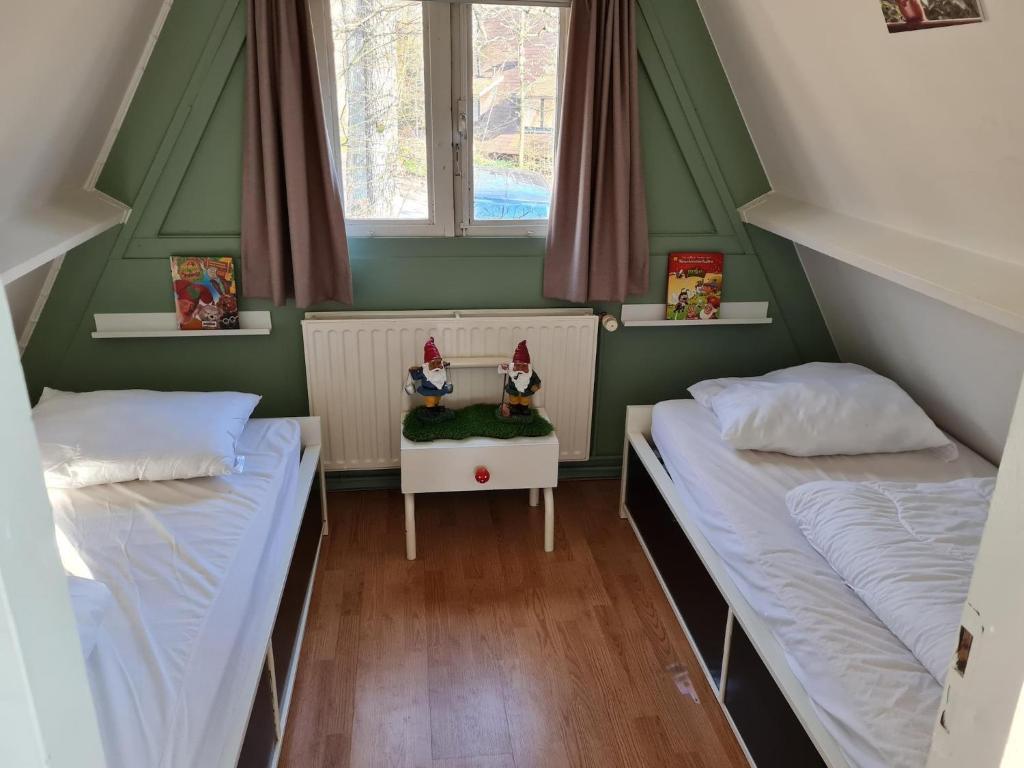 Duas camas num quarto com paredes verdes e janelas em Quiet Family Chalet in Durbuy Hills em Septon
