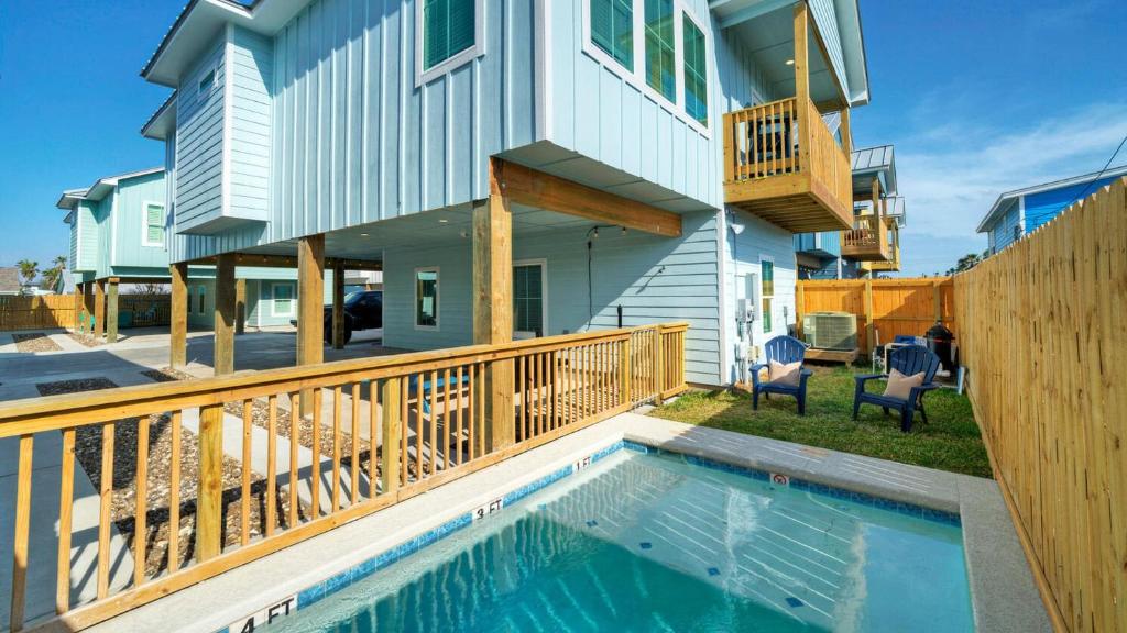 a house with a swimming pool in front of a house at Free Heated Pool Golf Cart Zone Sea La Vie by AvantStay in Port Aransas