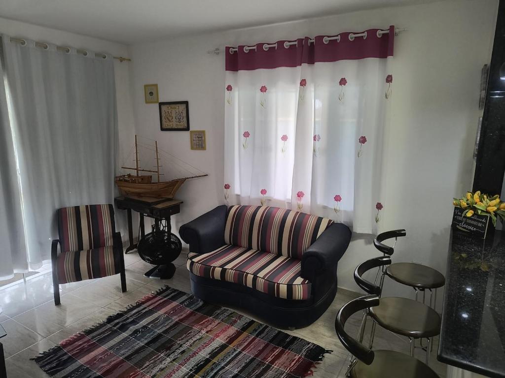 a living room with a couch and a chair at Casa da Lagoa Azul in Arraial do Cabo