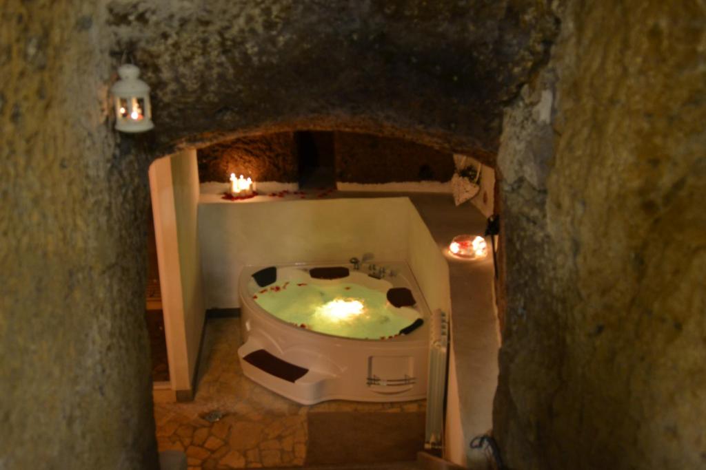 a bathroom with a bath tub in a cave at Ortaccio relais & private SPA in Vasanello