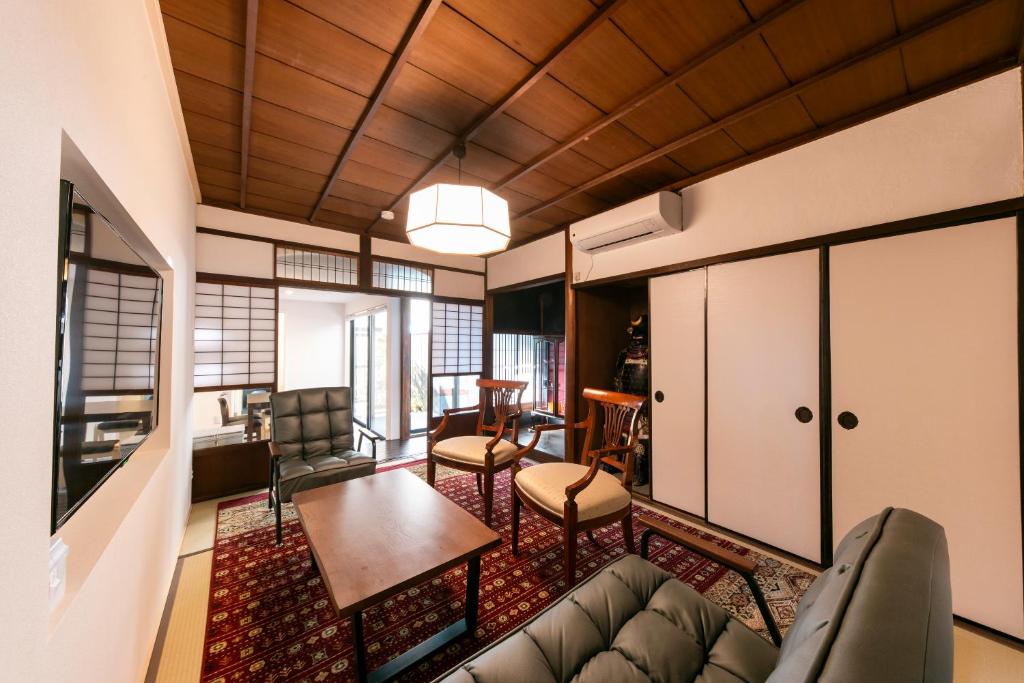 アトレチア祇園宇治別邸プレミアム في يوجي: غرفة معيشة بها أريكة وطاولة