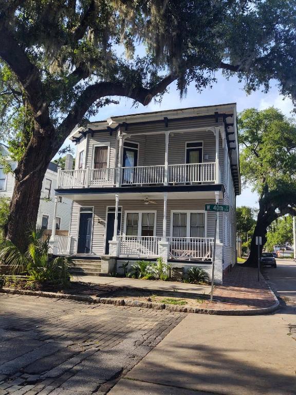 a white house with a balcony on a street at Cornerstone West Lower Unit in Savannah