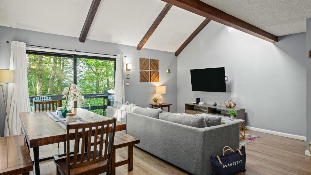 a living room with a couch and a table at Timberline Retreat by AvantStay Forest Views Minutes to Camelback Resort in Tannersville