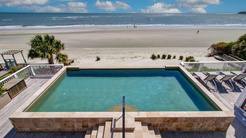 una piscina con una playa de fondo en 114 Ocean Boulevard by AvantStay Beachfront Infinity Pool Basketball Court Recently Renovated, en Sullivans Island