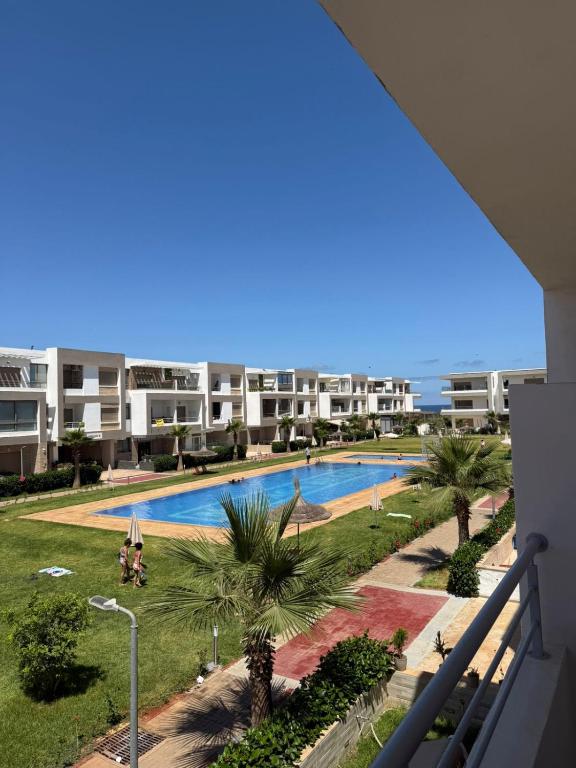a view of a swimming pool from a balcony of a apartment at 2BR Beach Apt, Pool, Luxury place in Mansouria