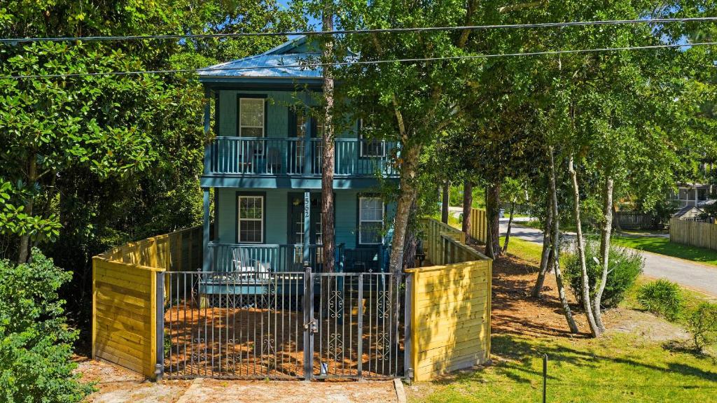 una casa verde con un balcón en los árboles en Coastal Soul 393 by AvantStay Near Boat Ramp Bay Private Yard, en Santa Rosa Beach