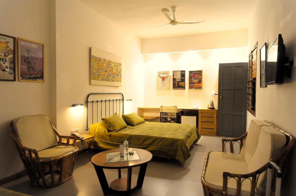 a bedroom with a bed and a table and chairs at Hôtel La Résidence in Saint-Louis