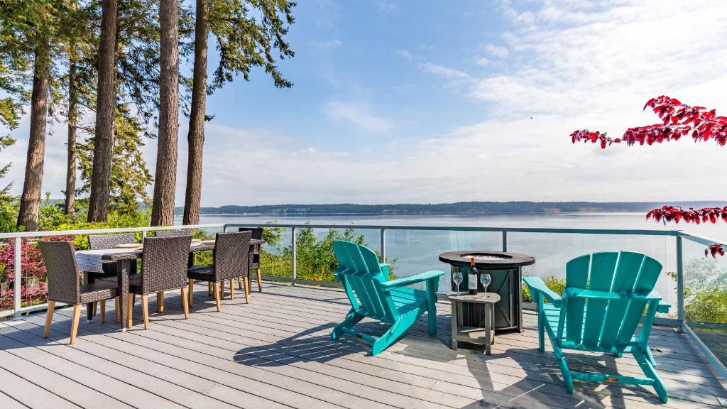 a deck with chairs and a table with a view of the water at Saratoga Vista by AvantStay Waterfront Views in Langley