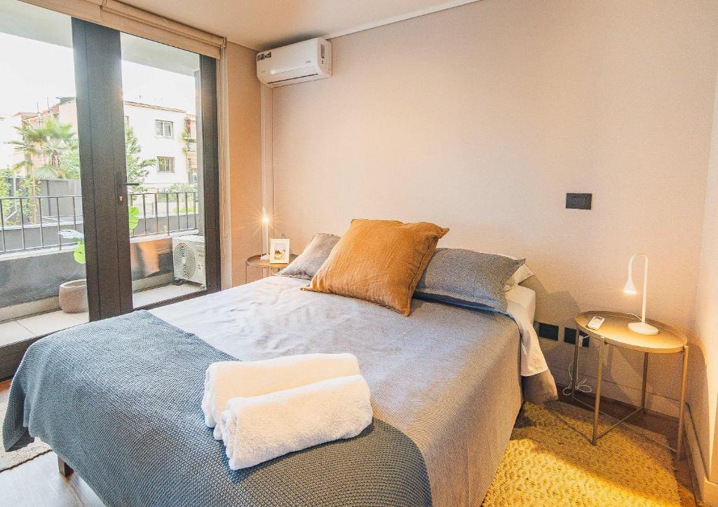 a bedroom with a bed and a large window at HOM I Lujoso Depto 2D2B, Ñuñoa con Estacionamiento in Santiago