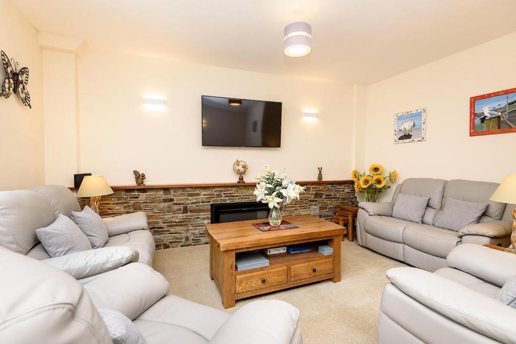 een woonkamer met banken en een flatscreen-tv bij Heart of Looe Apartment in Looe