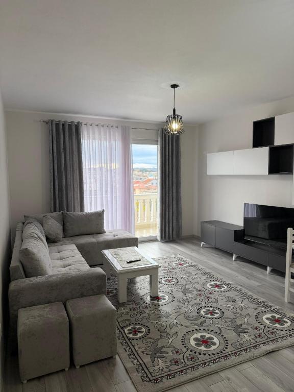 Modern 2-Bed Near Tirana and Airport with Balconies في Kamëz: غرفة معيشة مع أريكة وطاولة