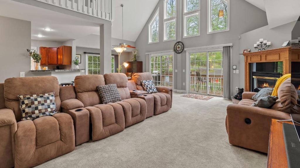 Una gran sala de estar con sofás y chimenea. en Chalet on Chalet by AvantStay Bright Cabin w Deck Fire Pit Near Lake, en Lake Harmony