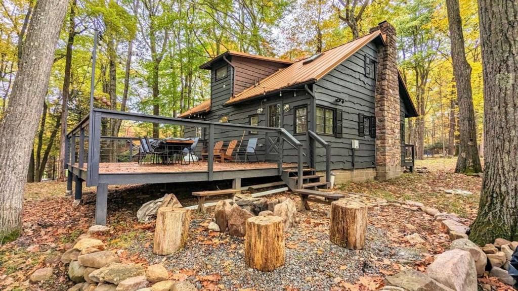 una cabaña de madera en el bosque con terraza en The Biddle House by AvantStay Breathtaking Views, en Lake Harmony