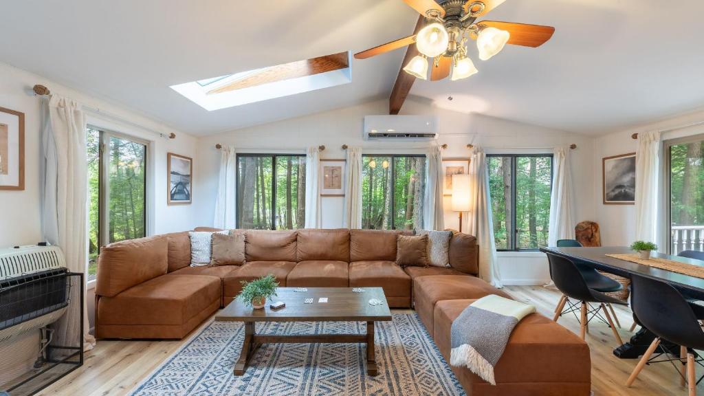 Lakeshore Oasis by AvantStay Private Beach Views Hot Tub Volleyball في Blakeslee: غرفة معيشة مع أريكة ومروحة سقف