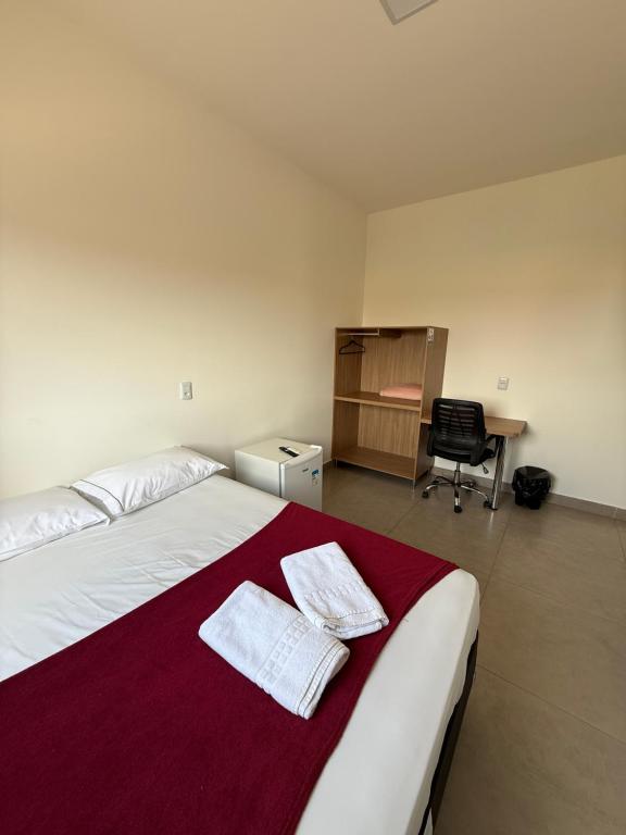 a bedroom with a large bed with two towels on it at Flat Central in Bonito