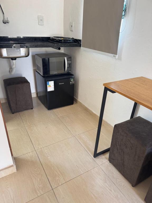 a room with a table and a microwave and a table at Park e Mar Studio quarto 1 in Penha