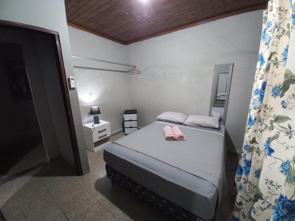 Un dormitorio con una cama con dos zapatos rosas encima. en Hospedaje carvajal, en David