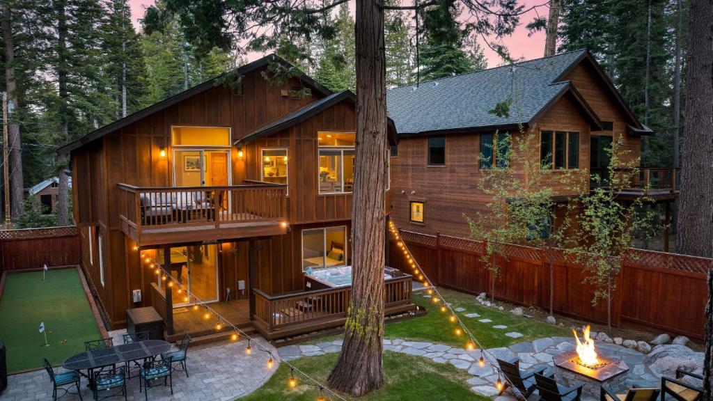 a cabin in the woods with a fire pit in the yard at Washoe Chalet by AvantStay Game Room Hot Tub Putting Green Fire Pit in Tahoma