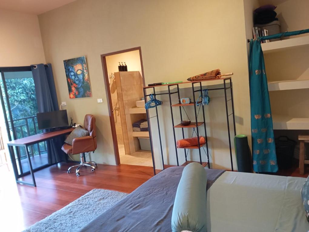 een slaapkamer met een bed en een bureau en een kamer bij Butterfly Cottage Tracy Island Had Yao in Ko Pha Ngan