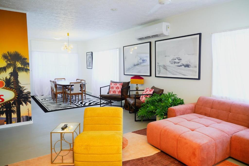 Pet Friendly Sleeps 8 Bowen Holiday House في بوين: غرفة معيشة مع أريكة وكراسي وطاولة