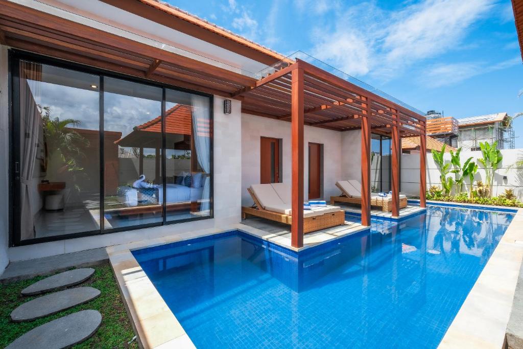 una piscina a sfioro in una villa con pareti in vetro di Three Brothers Munggu Villas and Suites Seseh Beach a Pererenan