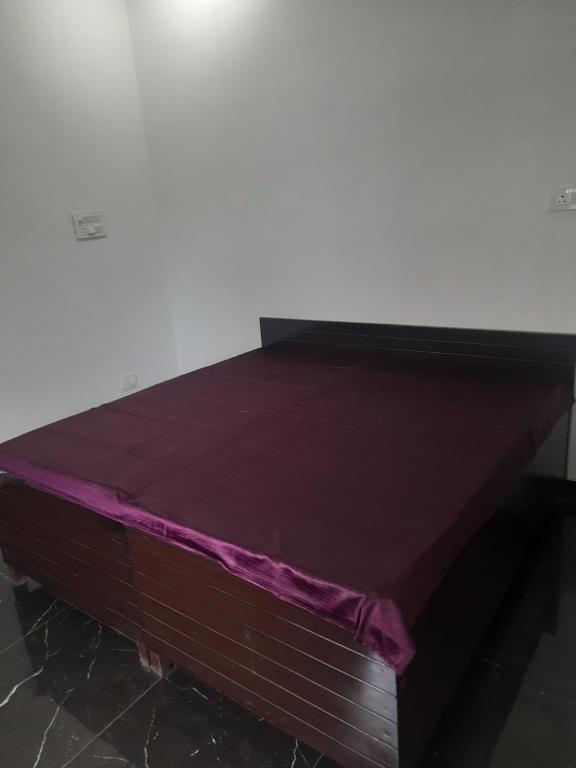 a bed with a purple sheet on top of it at DS Villa in Noida