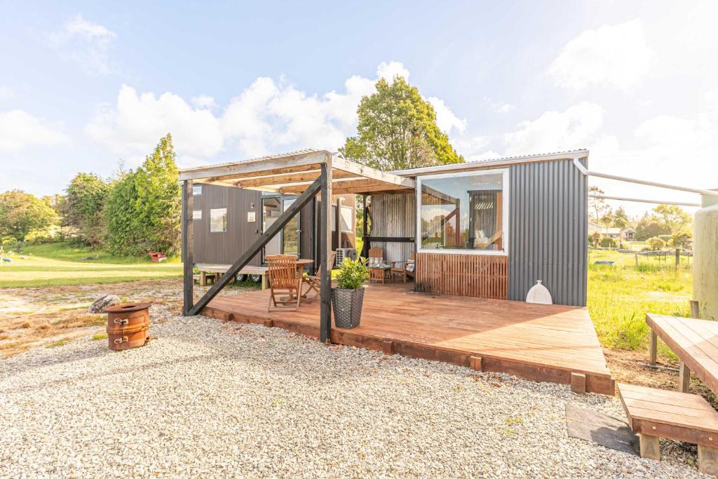 RuatapuにあるRimu View 3 by Tiny Awayの木製デッキとベンチ付きの小さな家