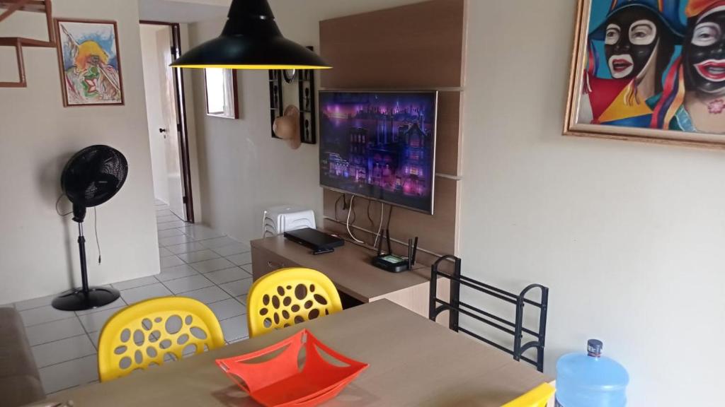 Un comedor con una mesa y sillas amarillas. en FLAT MONTE CASTELO CONDOMÍNIO GRAVATÁ NA FRENTE DA ÁREA DE LAZER - Pe, en Sairé