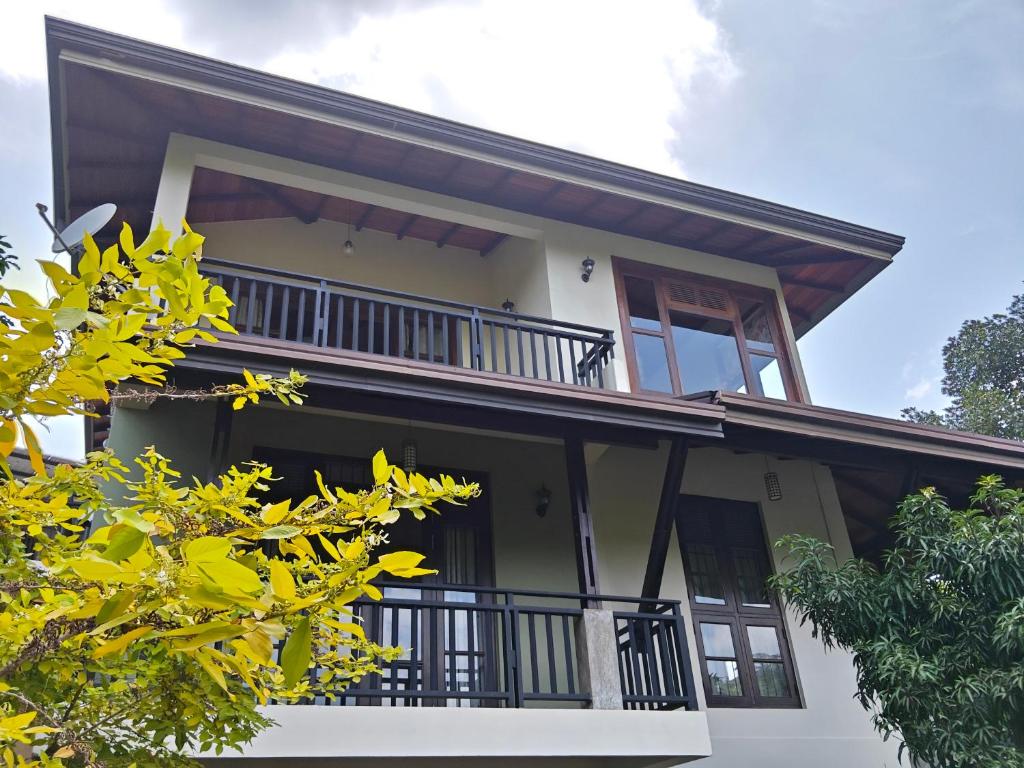 uma imagem de uma casa com uma varanda em Kandy Villa em Kandy