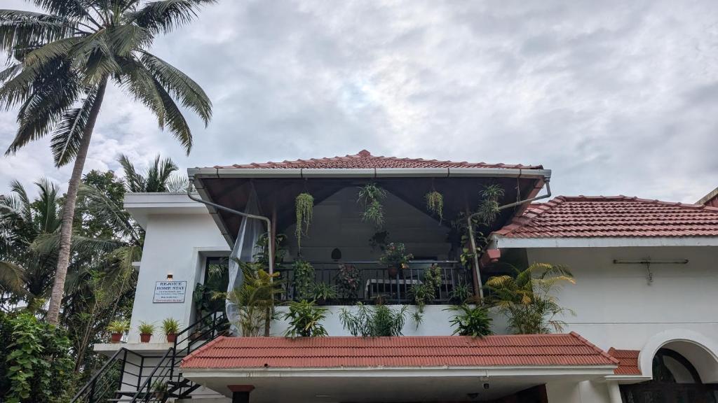 a house with a balcony with plants on it at REJOICE Homestay in Kalyānpur
