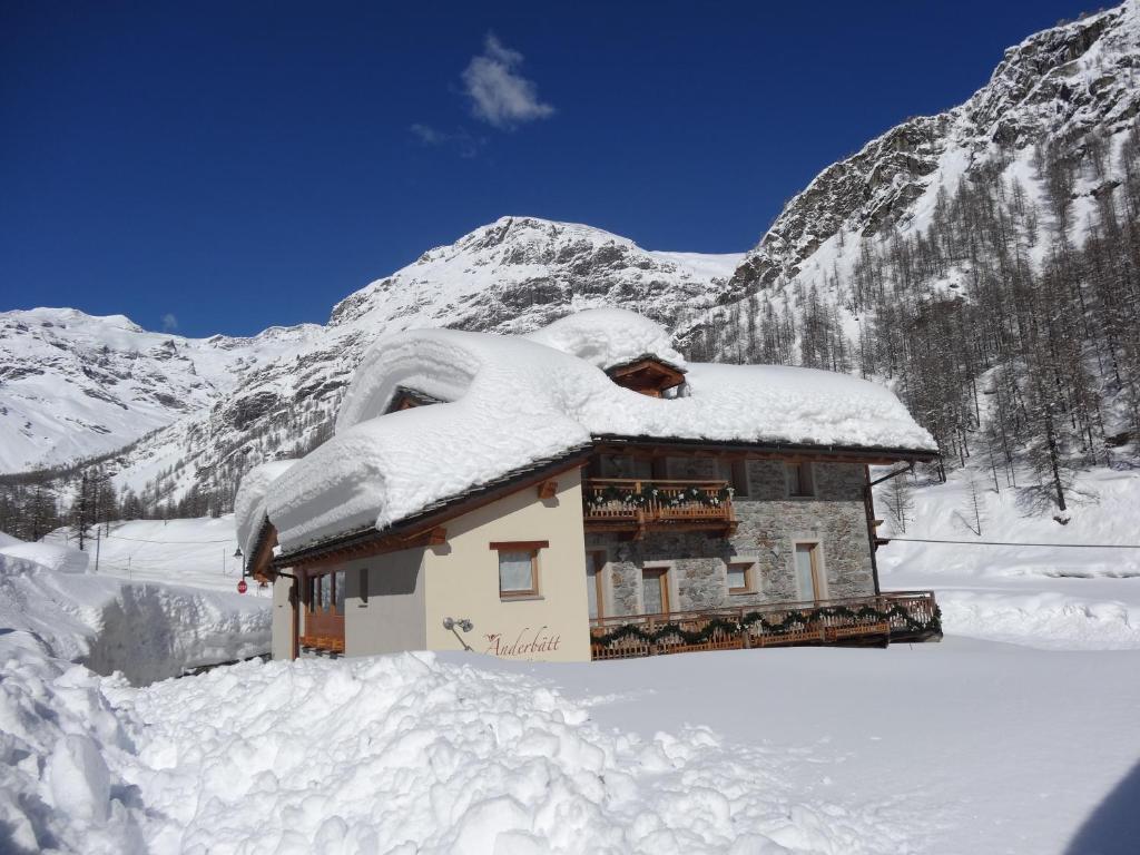 a building covered in snow in front of a mountain at Anderbatt in Gressoney-la-Trinité