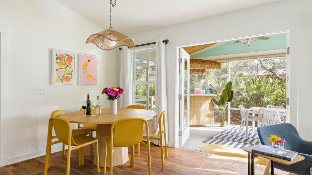 ein Esszimmer mit einem Tisch und gelben Stühlen in der Unterkunft Beach Bungalow 1blck to Beach w Hot Tub Game Room Haven Grove by AvantStay in St. Augustine