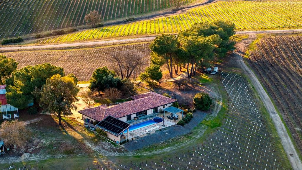 an aerial view of a house with a pool and a vineyard at Private Pool Firepit Wine Room Near Top Paso Wineries Devi Ranch in Paso Robles