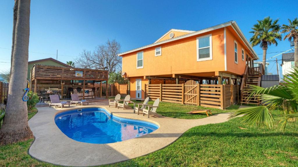 a house with a swimming pool in the yard at Coastal Retreat w Pool BBQ Sunset Views Beers and Sunshine by AvantStay in Port Aransas