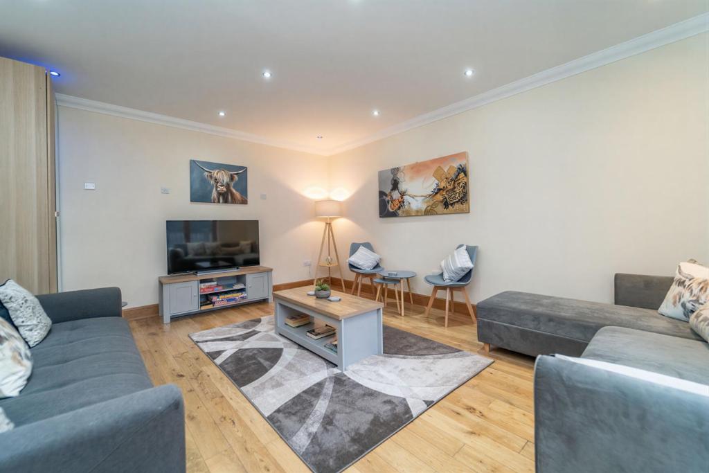 a living room with a couch and a tv at Family Friendly 3BR Townhouse with 6 Beds and Parking in Edinburgh
