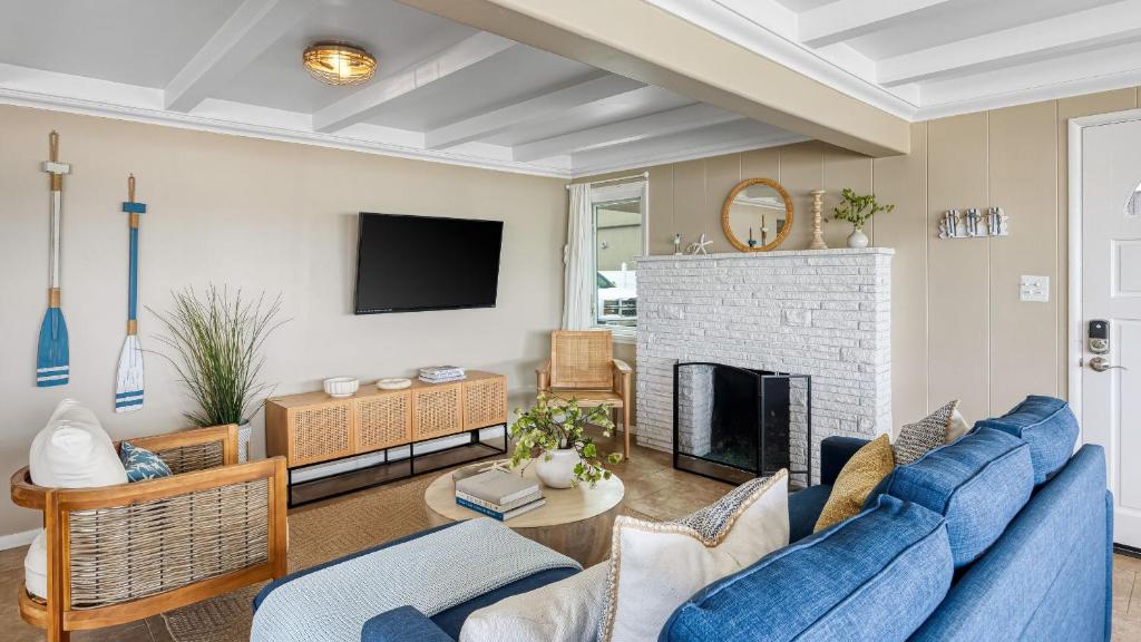 Waterfront Views Shared Dock Short Walk to Beach Shops Surf Edgewater B by AvantStay في شاطئ نيوبورت: غرفة معيشة مع أريكة زرقاء ومدفأة