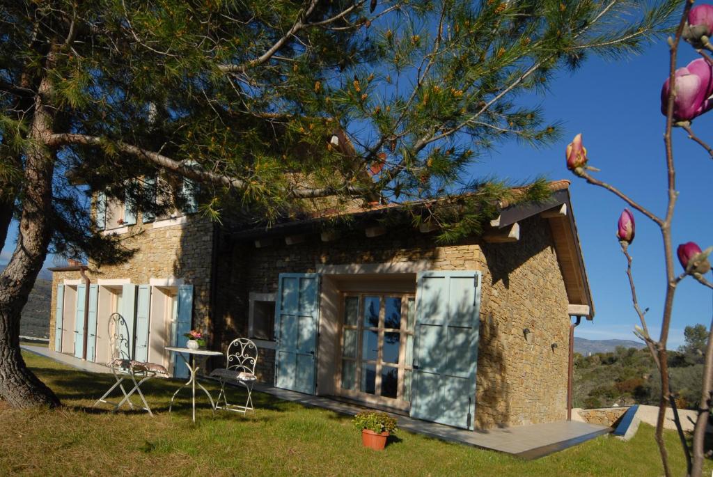 une petite maison en pierre avec une table et un arbre dans l'établissement B&B Normanna, à Dolceacqua