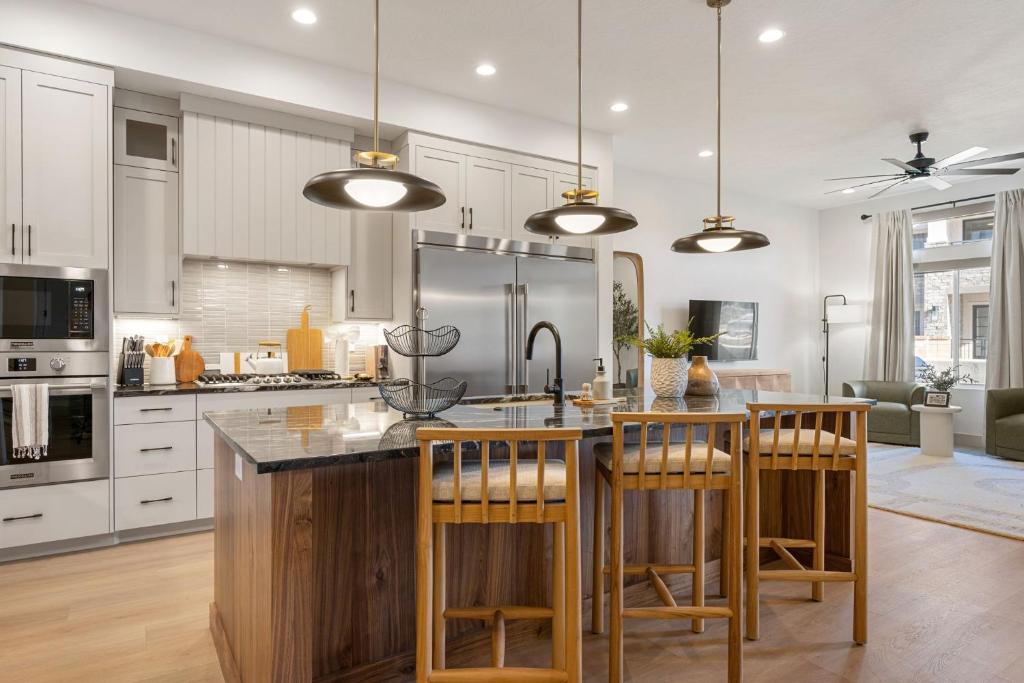 a kitchen with white cabinets and a kitchen island with bar stools at The Fish Bowl townhouse in St. George