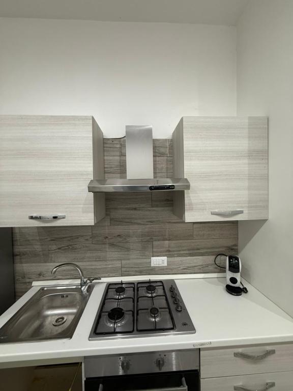 a kitchen with a stove and a sink at Metro Stay piscinola in Naples