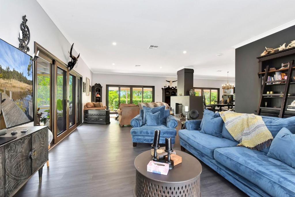 Black Cat Manor at B&W Estate في Luskintyre: غرفة معيشة مع أريكة وكراسي زرقاء