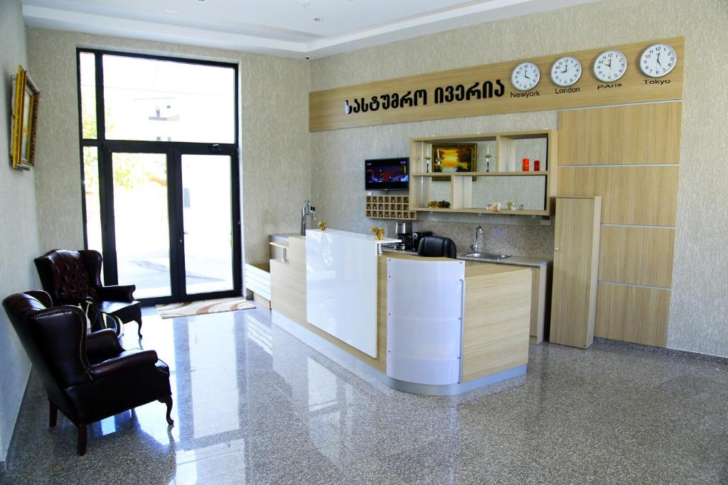 a restaurant with a counter and chairs in a room at Iveria Hotel in Khashuri