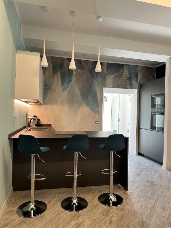 a kitchen with two bar stools and a counter at Leyand exclusive House in Torre del Lago Puccini