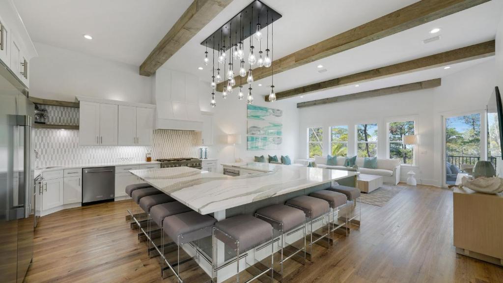 a kitchen with a large dining table and leather chairs at Priv Heated Pool Spa Golf Cart Included 7BDR Sleeps 20 30A Serenity Sands in Santa Rosa Beach