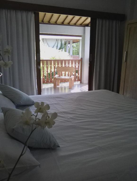 a bedroom with a large bed with white sheets at Ju'Blu Hotel in Lovina