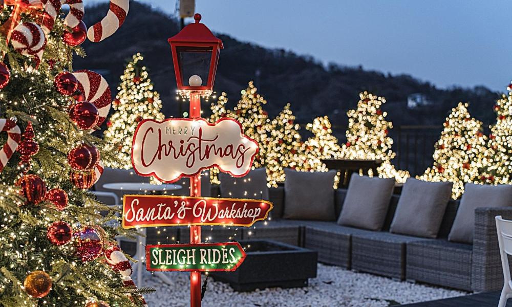 a christmas yard with a christmas sign and a christmas tree at Chuncheon Bali 376 in Chuncheon