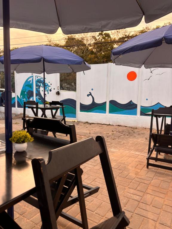 um par de mesas com guarda-sóis num pátio em Primo`s 2 Suites & Hostel em Búzios