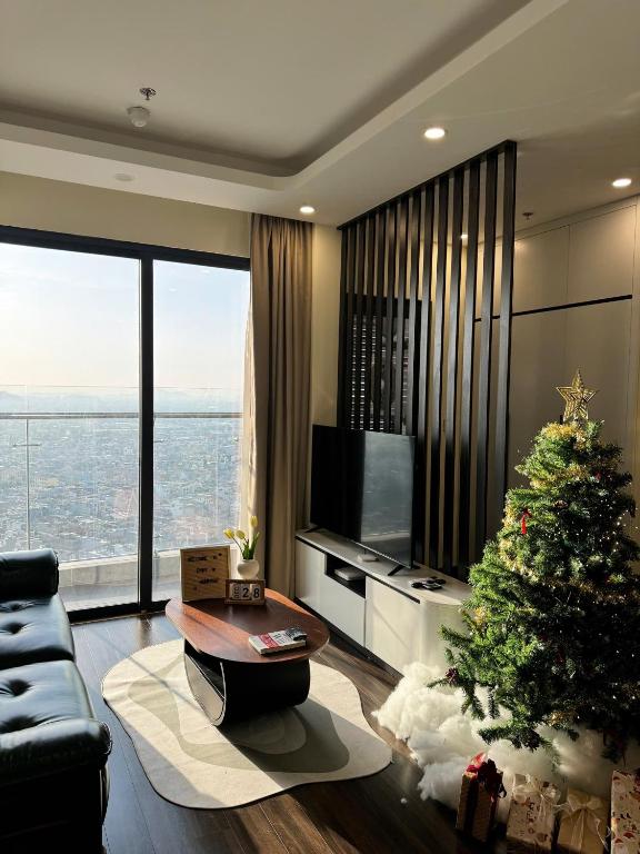 a living room with a christmas tree and a television at Hoàng Huy Commerce Võ Nguyên Giáp Enny Homestay in An Khê
